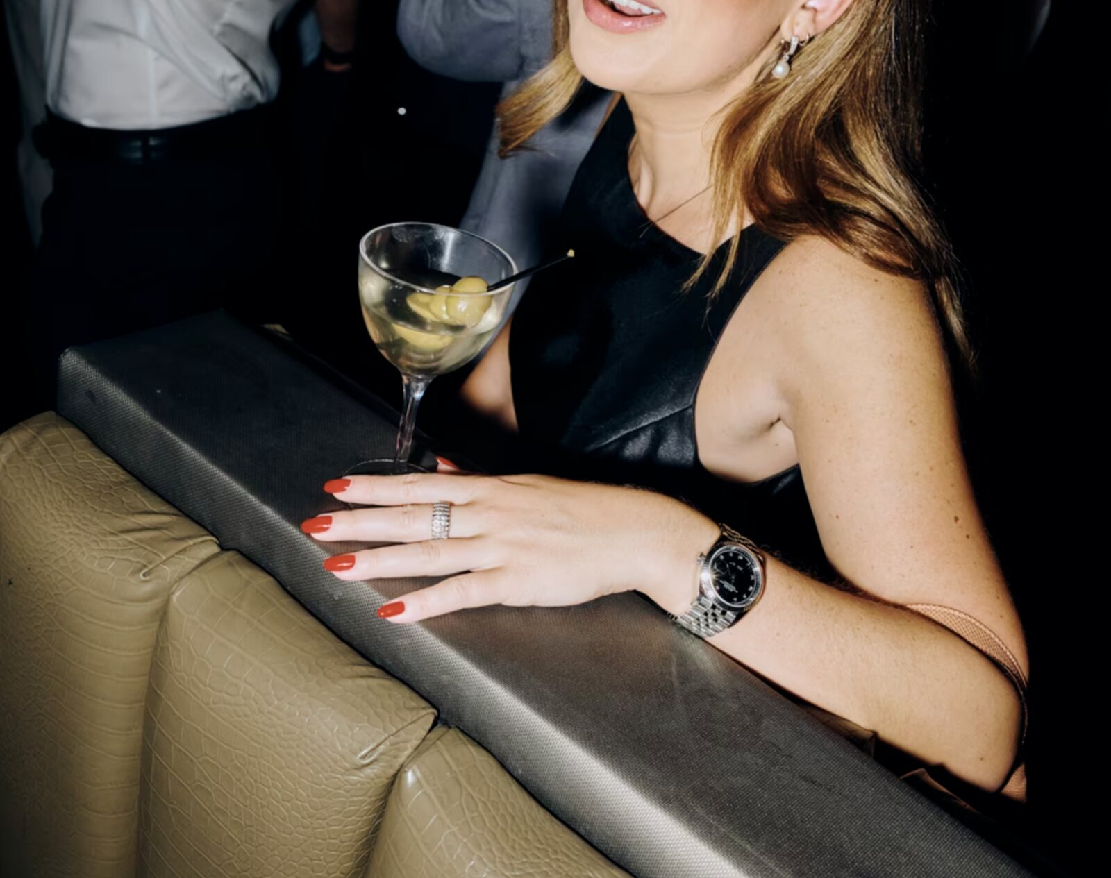 Raquel Debono at a Make America Hot Again mixer, a martini in front of her, her hand resting on the back of a booth