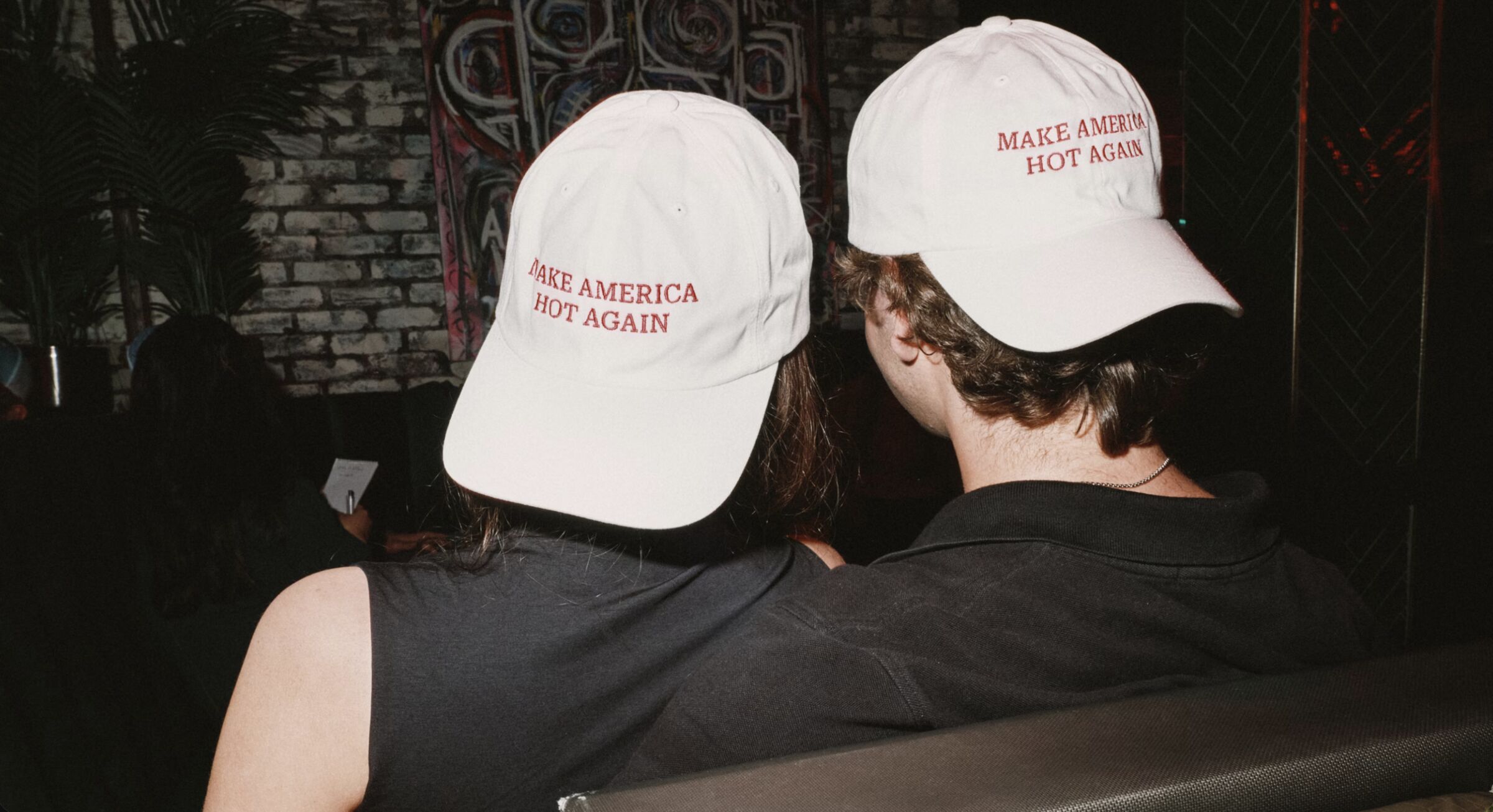 Two members from behind wearing white Make America Hot Again caps